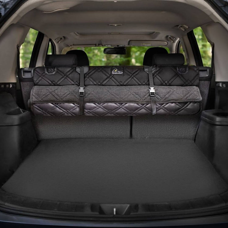 Meadowlark cargo liner rolled up and hanging on vehicle backseats in trunk.